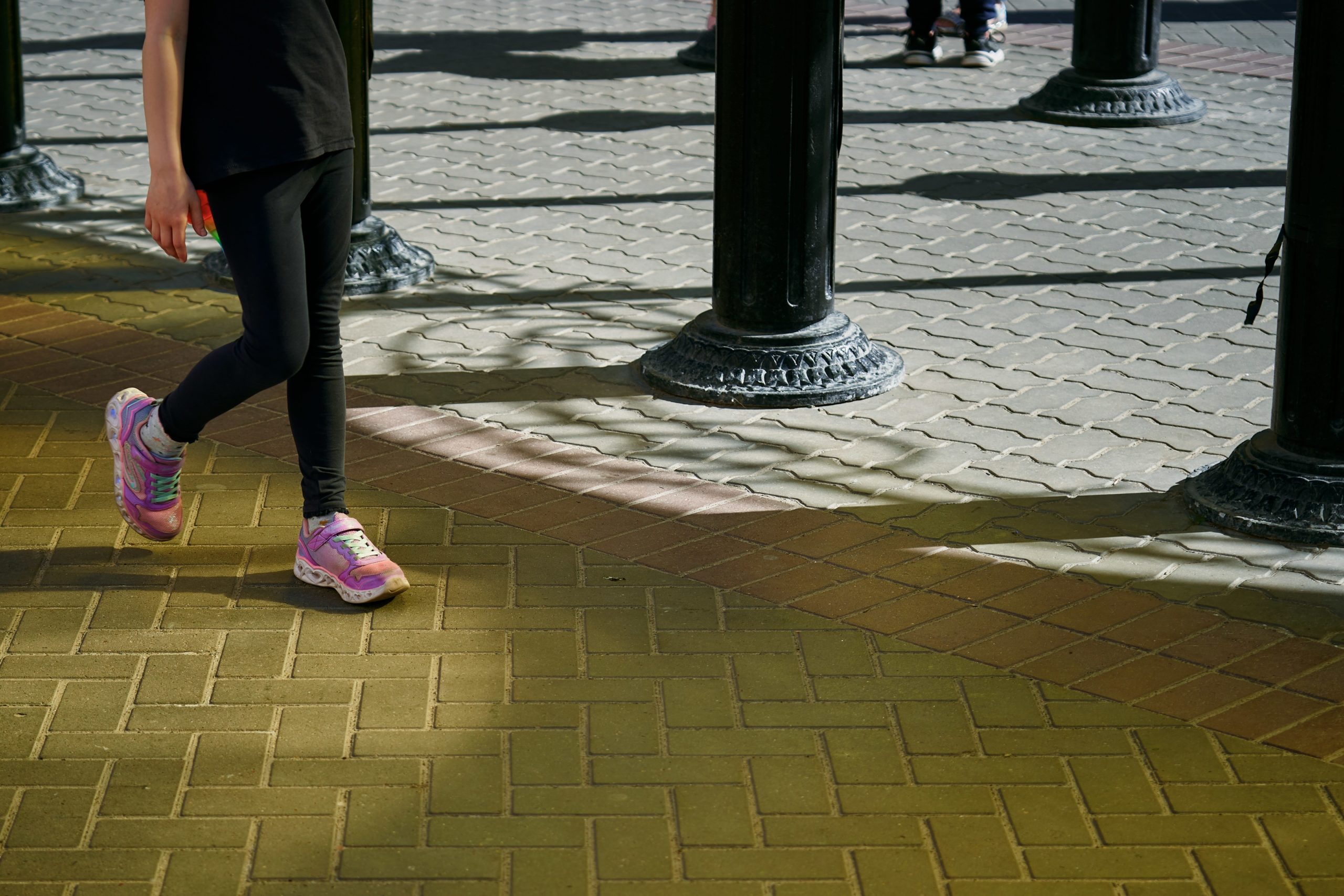 Gros plan sur une personne en train de lacer ses chaussures de course colorées avant de partir courir, symbolisant la préparation et l