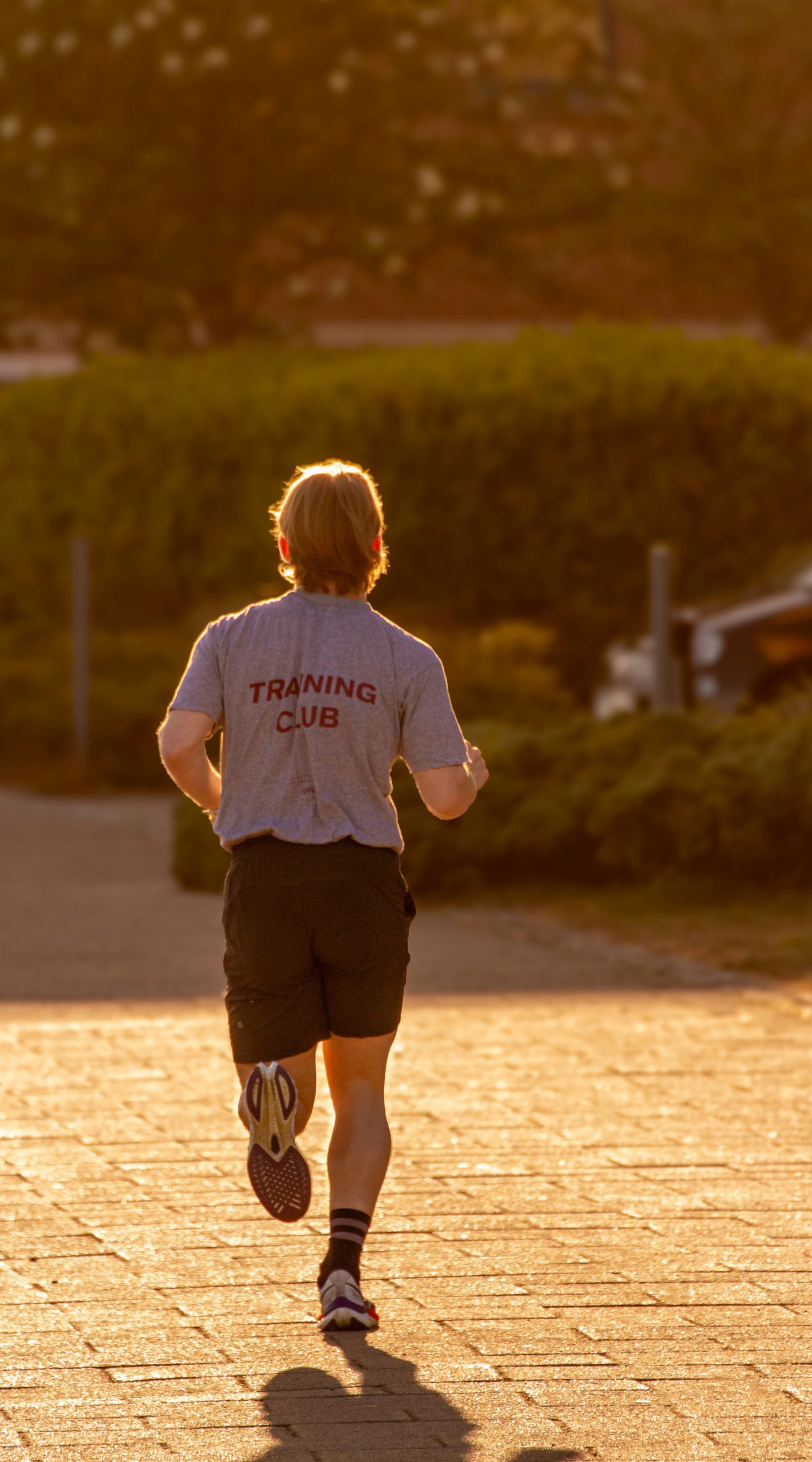 A diverse group of runners stretching together before a training session in a park.
