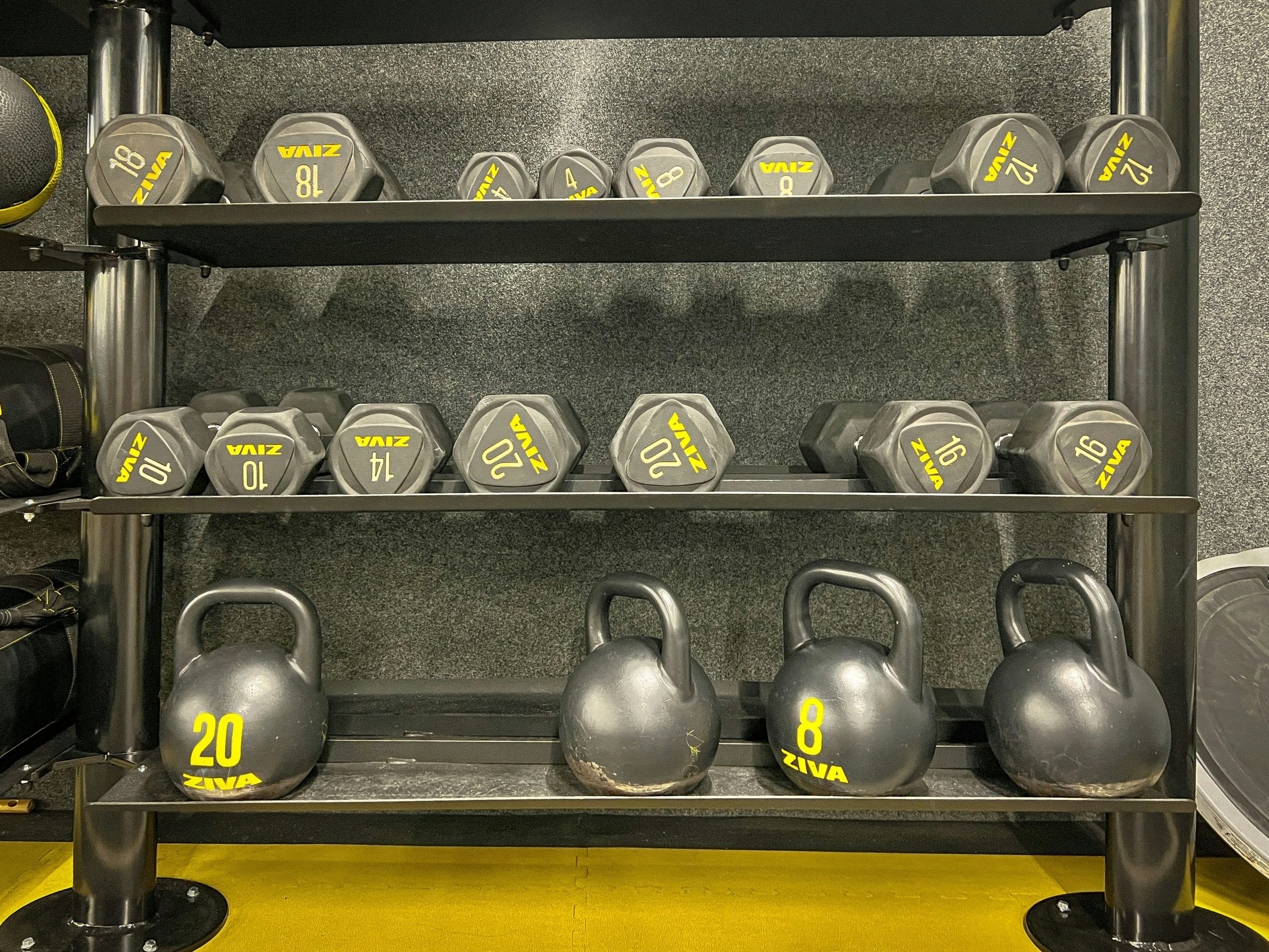 Close up photo of weights and kettlebells in a gym with natural lighting