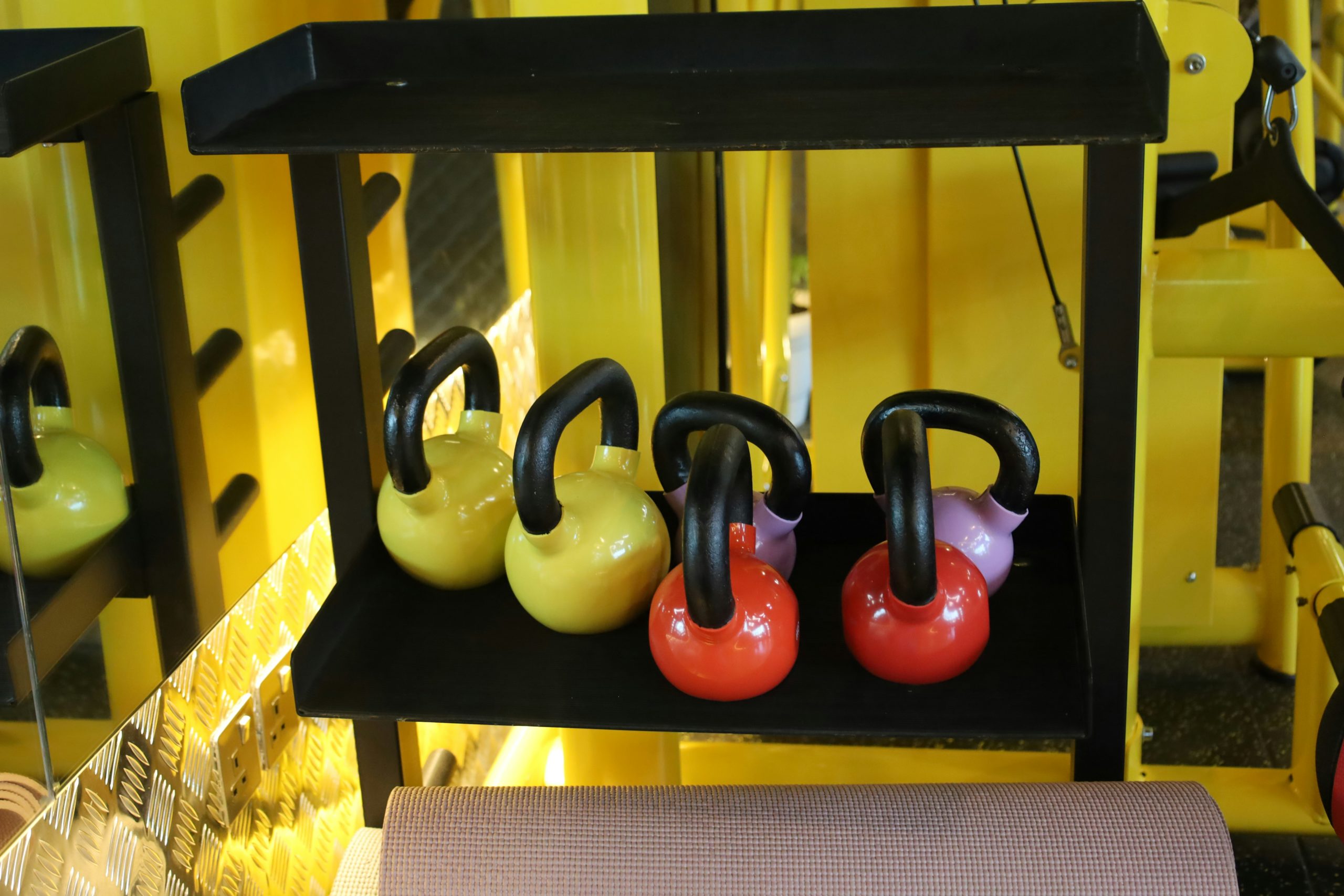 Close up of heavy kettlebells and dumbbells in a gym setting