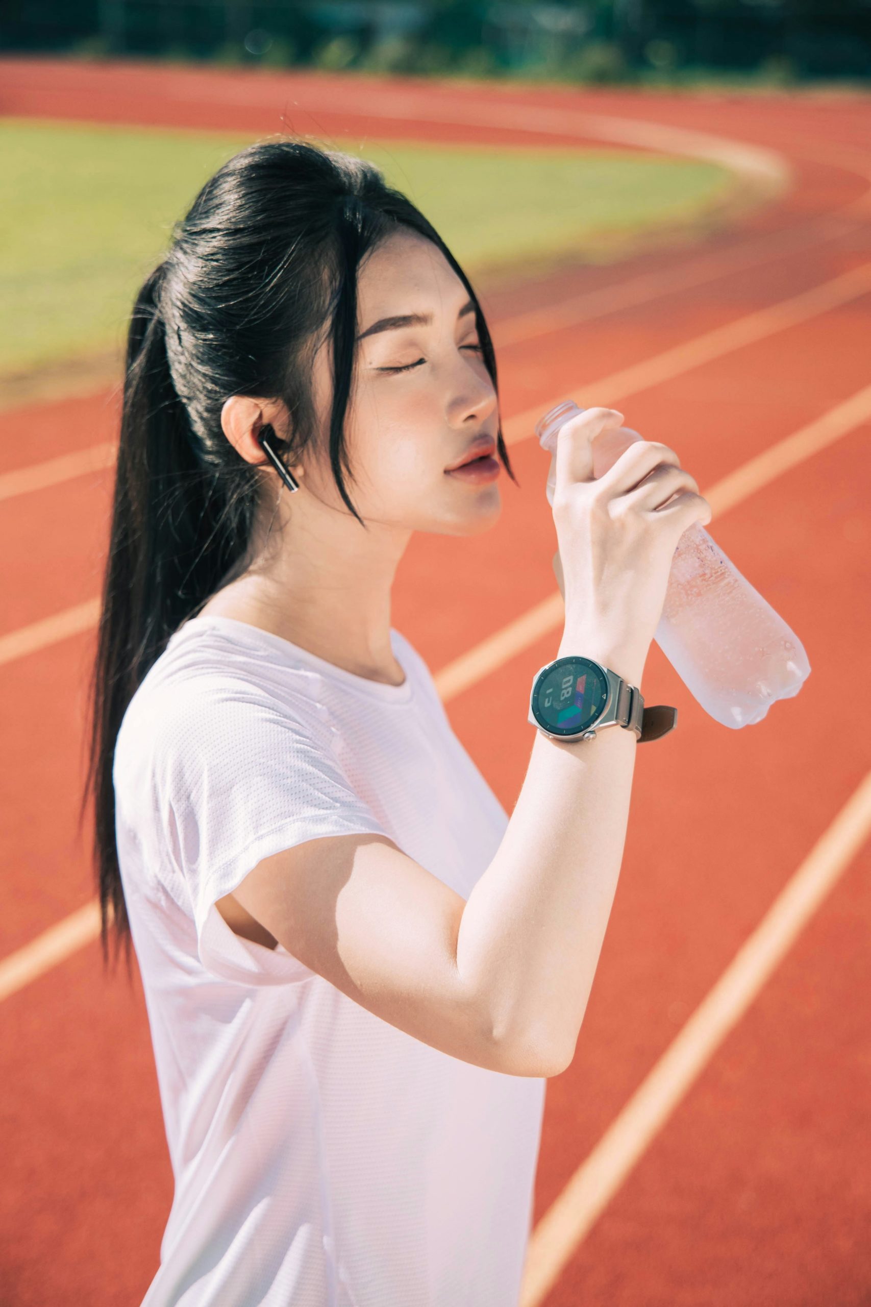 Close-up of a stopwatch and a water bottle on a gym floor