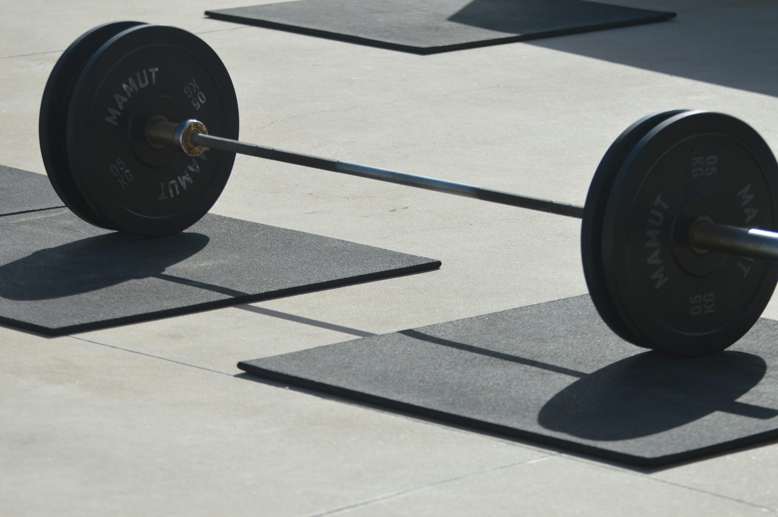 Close up of a barbell with weights in a gym environment