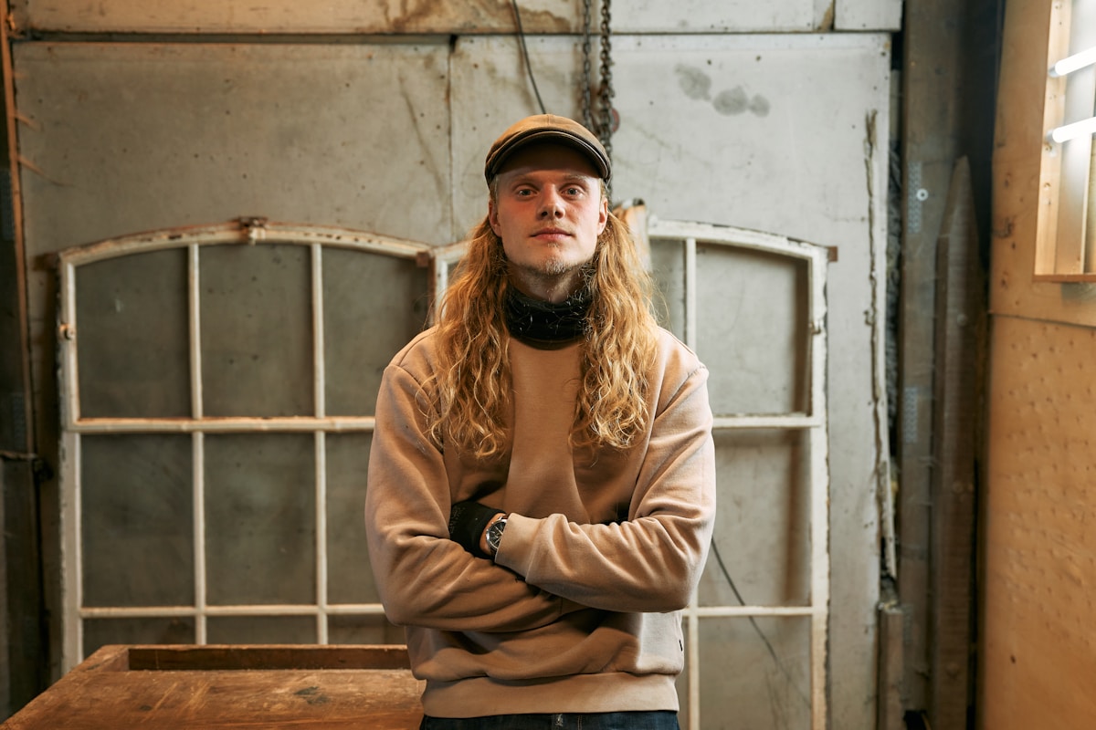 A man standing in front of a window with his arms crossed