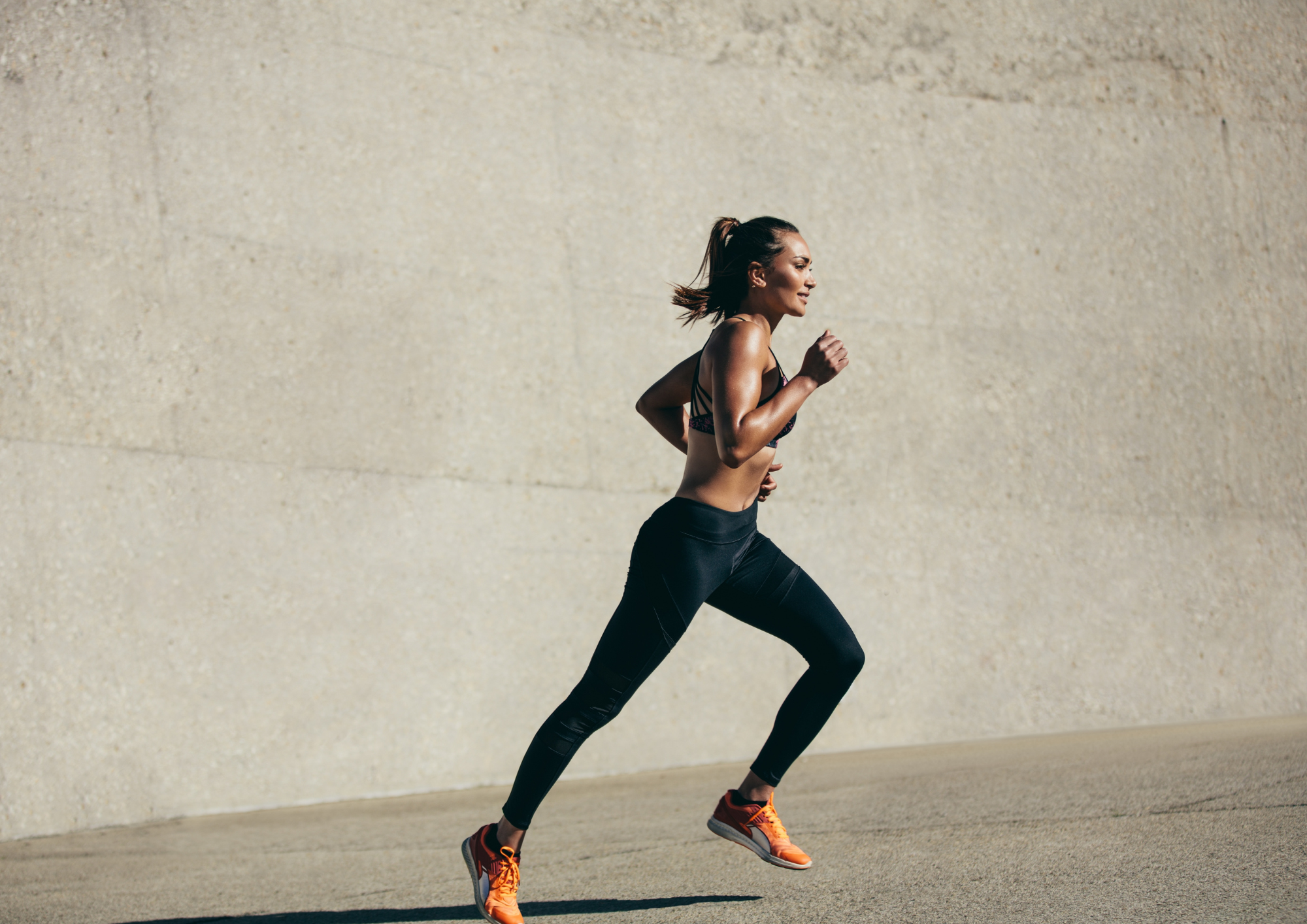 Gros plan sur des chaussures de course sur un sentier ou une piste par une journée ensoleillée.