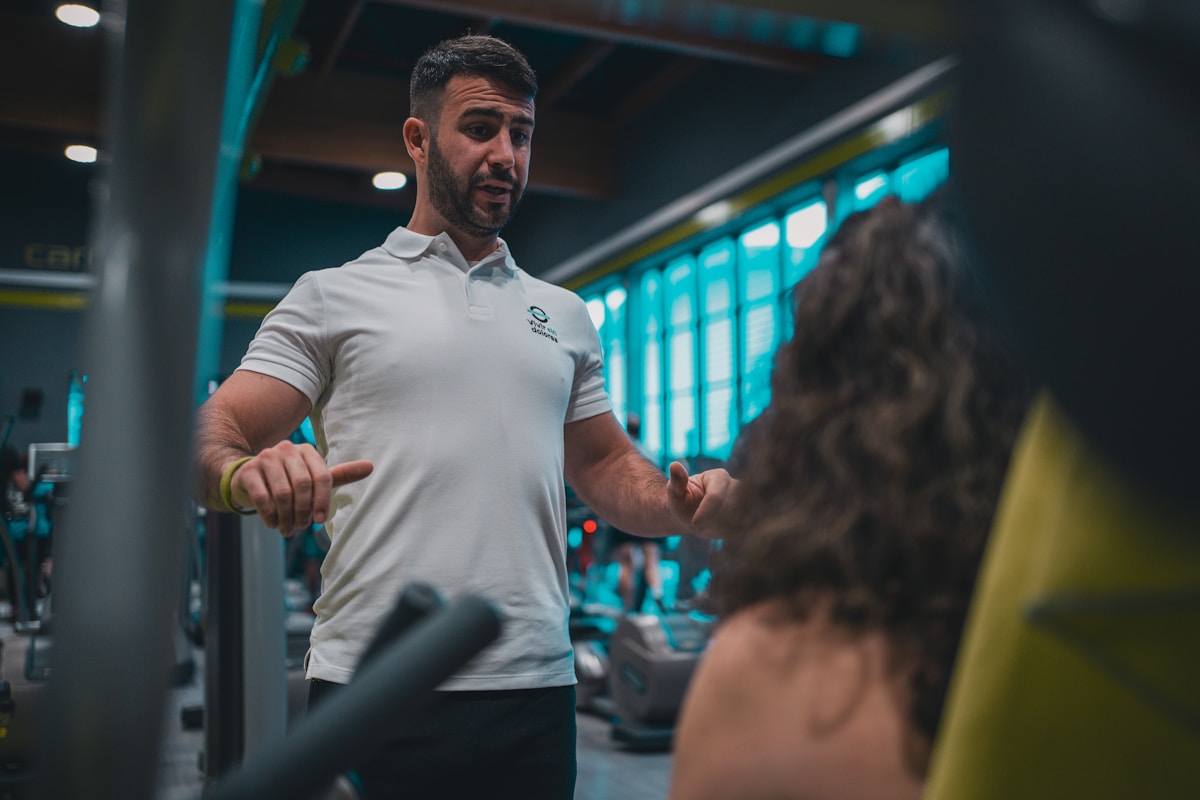 A man in a white shirt and black pants in a gym