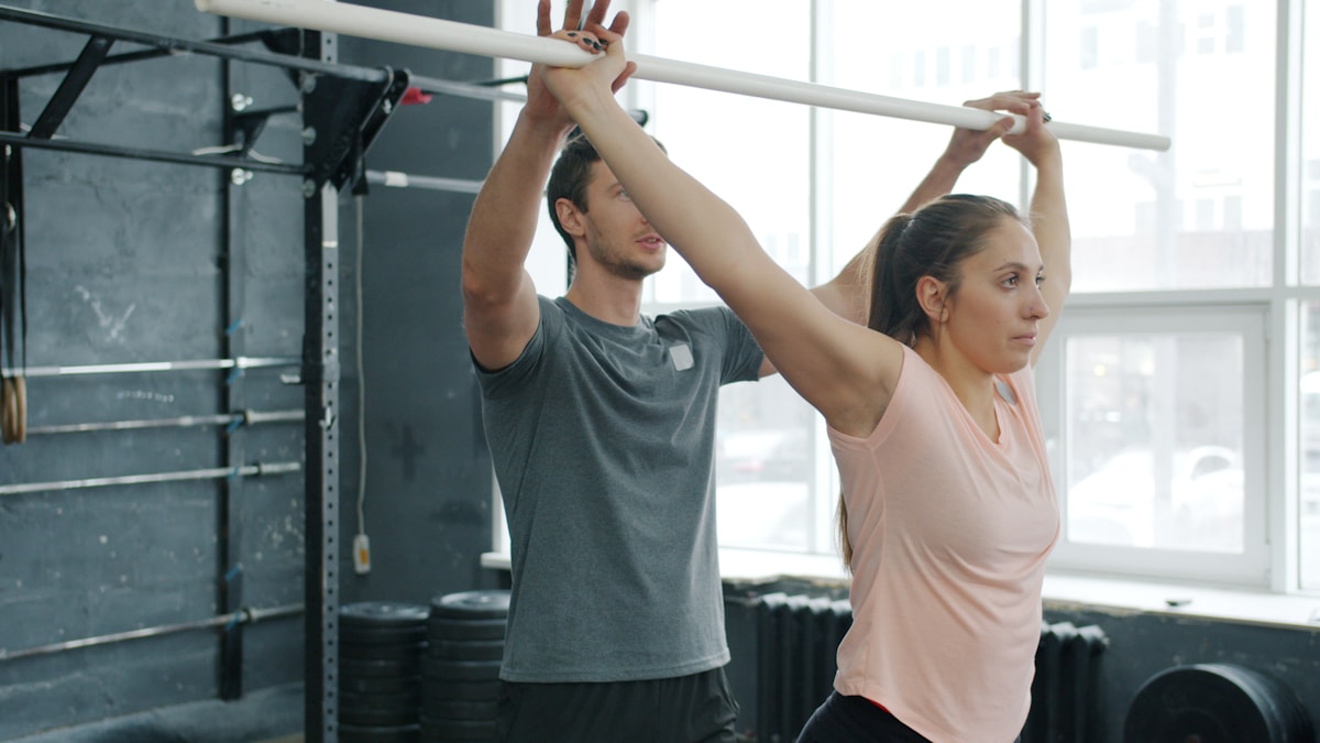 Deux personnes s'étirant ensemble dans une salle de gym.