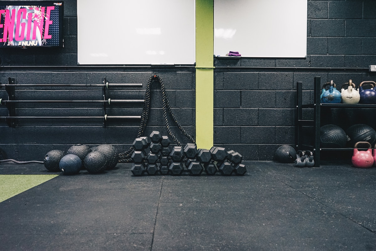 Salle de gym avec équipements d'entraînement, haltères et cordes.
