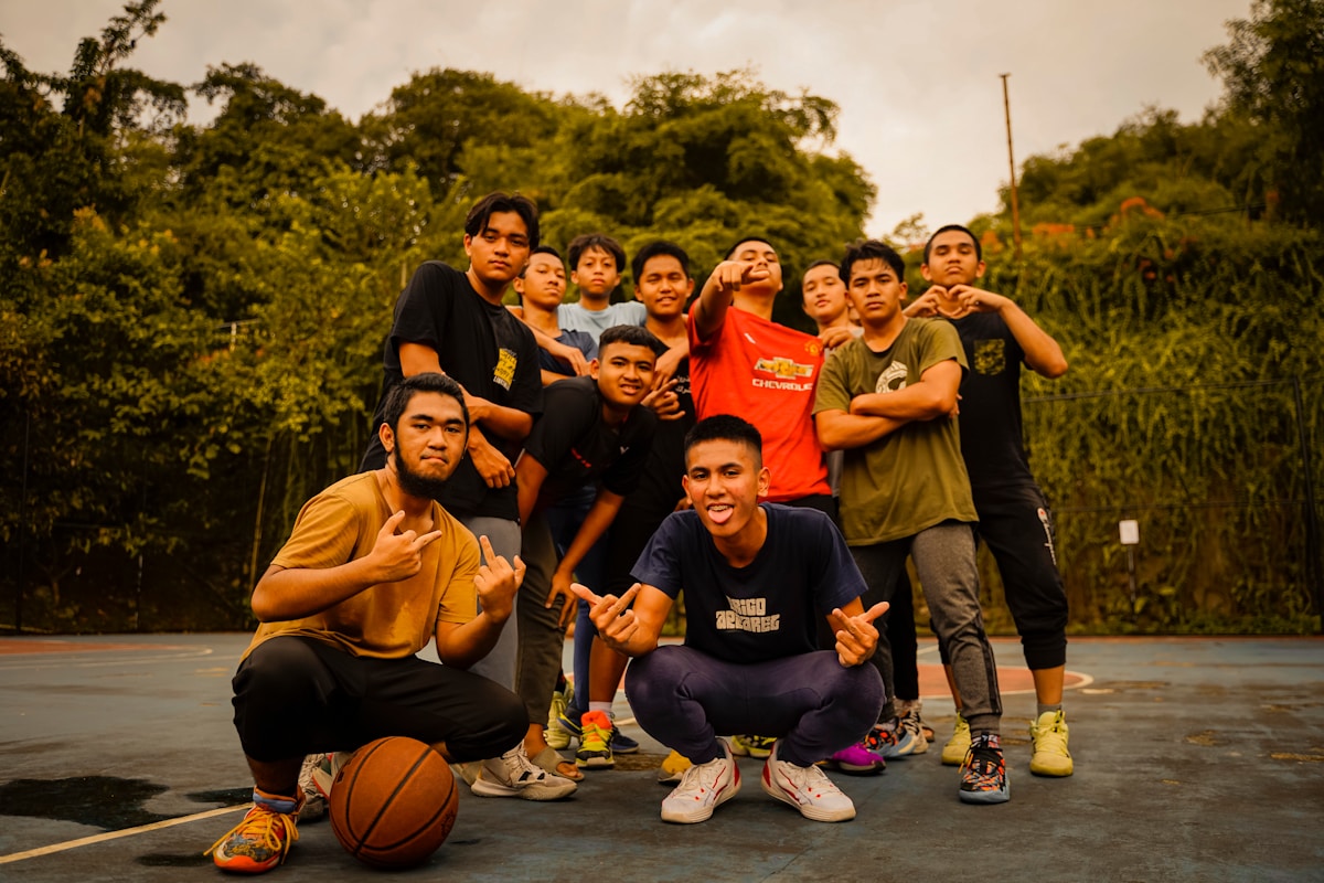 Groupe d'amis jouant au basket-ball dans un parc verdoyant.