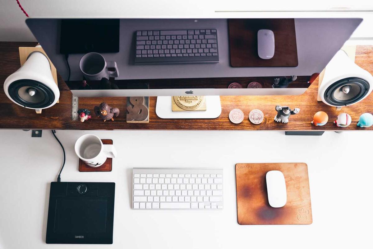 Bureau avec ordinateur, enceintes et accessoires.