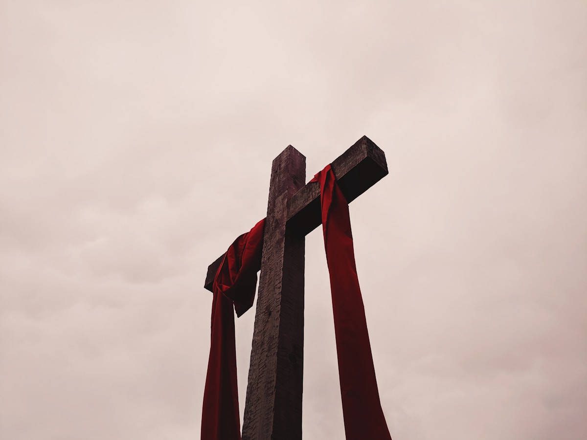Vue en contre-plongée d'une croix avec un vêtement rouge.