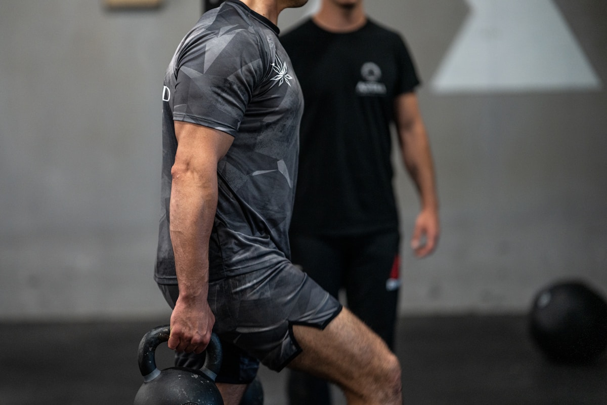 Deux hommes en tenue de sport, l'un portant un t-shirt gris imprimé.