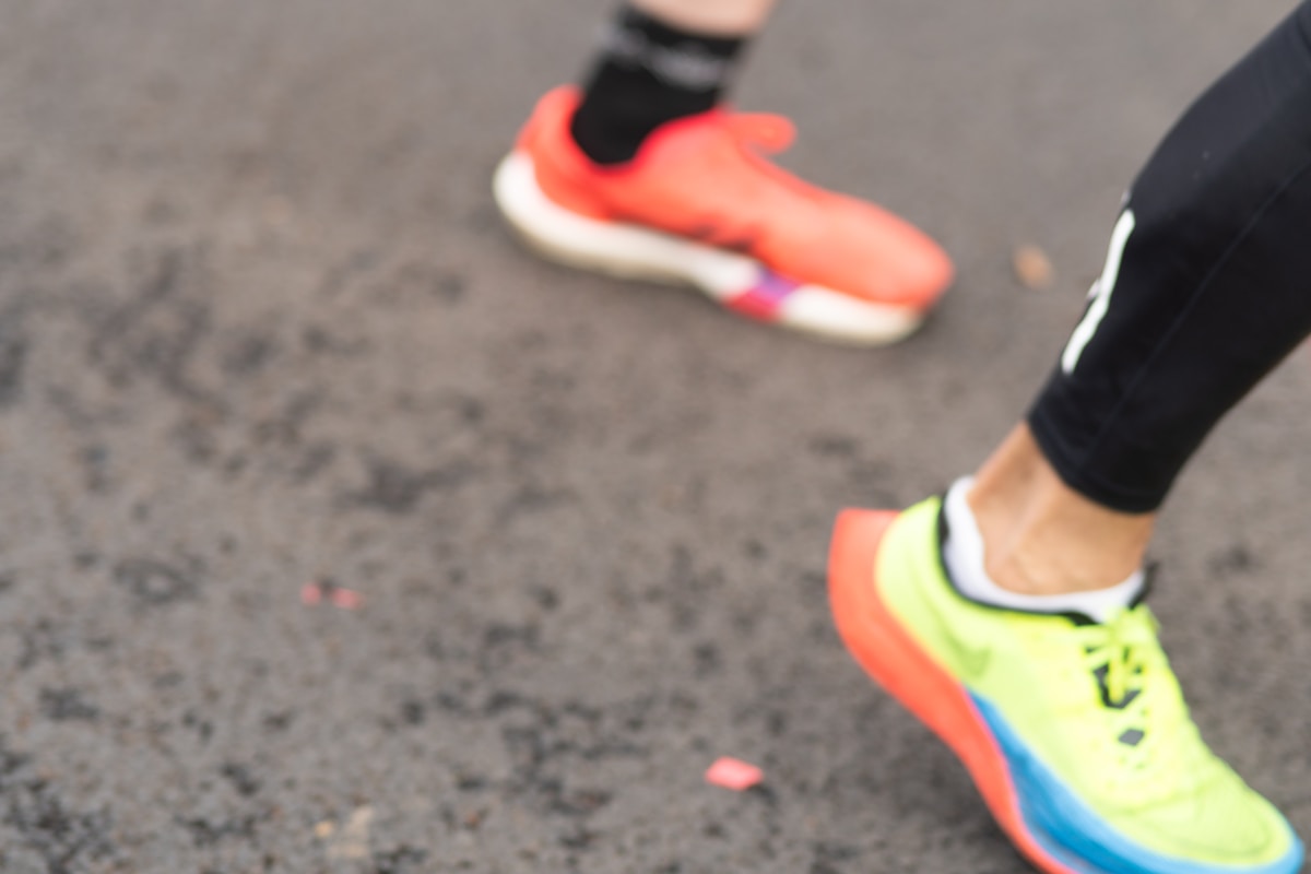 Chaussures de sport colorées sur un sol gris.