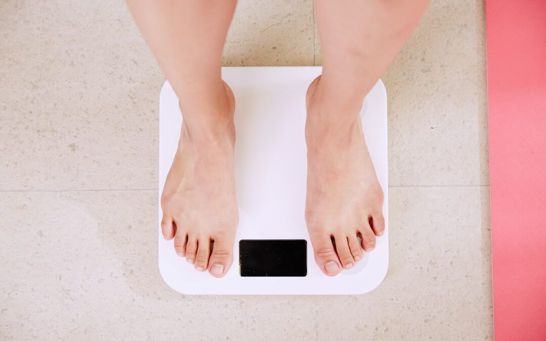 calculer imc et objectif poids - person standing on white digital bathroom scale