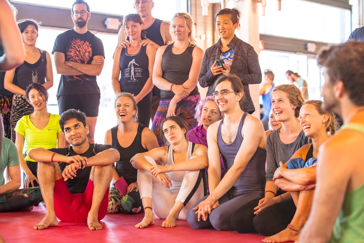 Groupe de personnes pratiquant le yoga dans un studio lumineux.