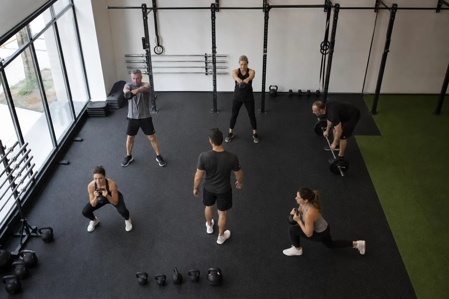 Groupe de personnes s'entraînant dans une salle de gym équipée.