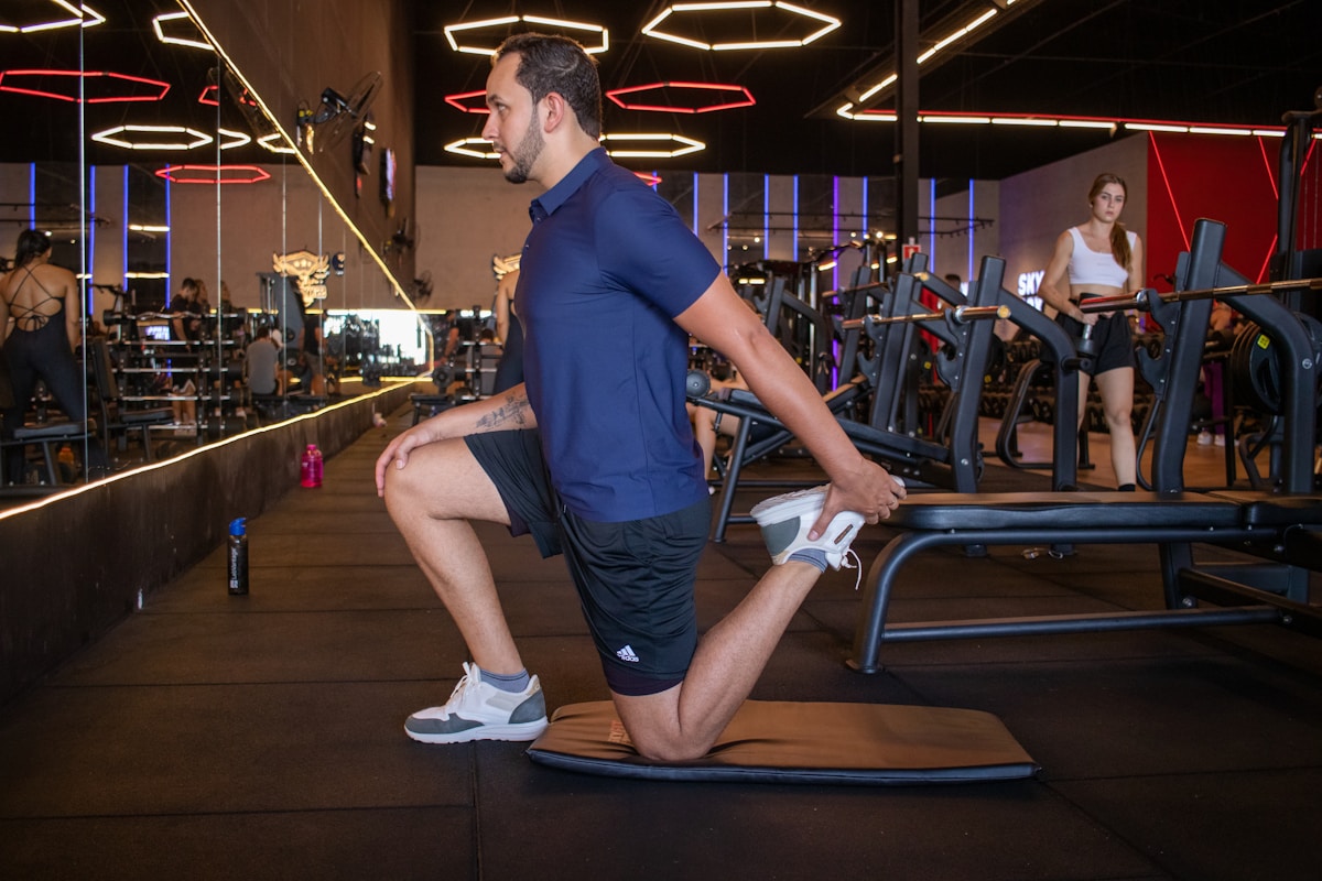 Un homme s'entraîne sur une machine dans une salle de sport moderne.