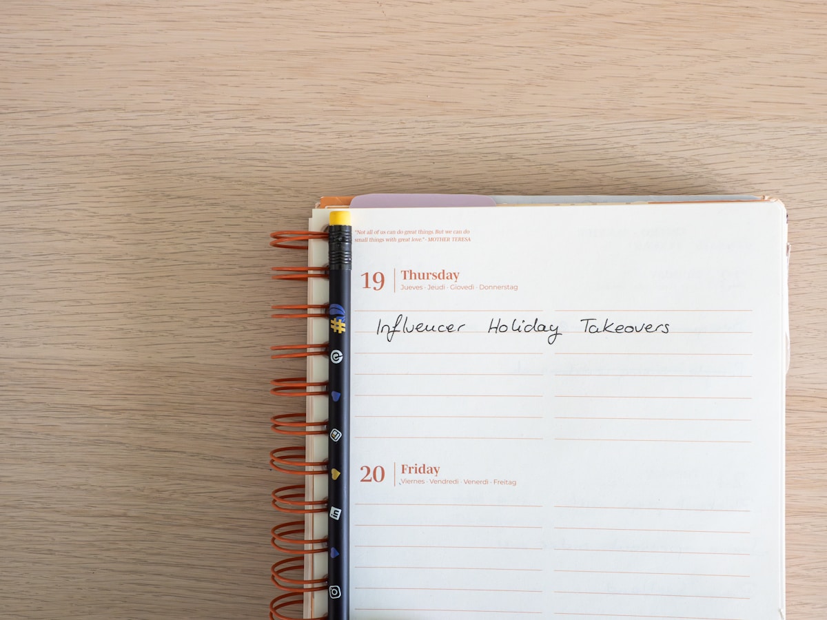 Calendrier hebdomadaire avec notes manuscrites sur les prises de contrôle des influenceurs pendant les vacances.