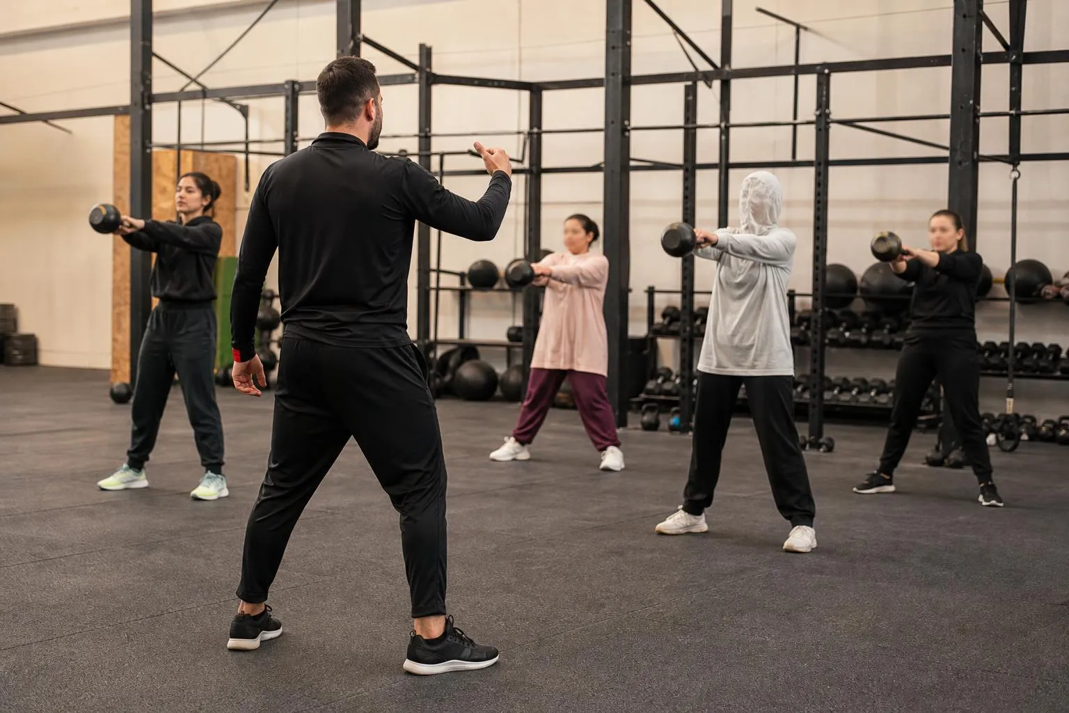 Groupe de personnes s'entraînant avec des haltères dans une salle de gym.
