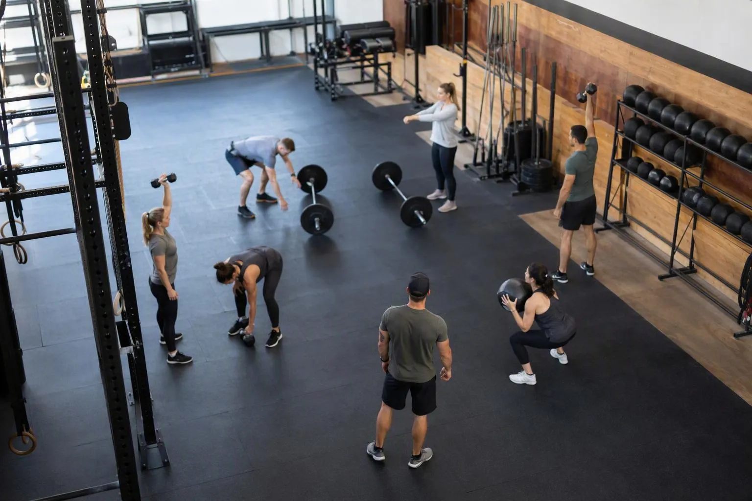 Salle de gym avec équipements et personnes s'entraînant.