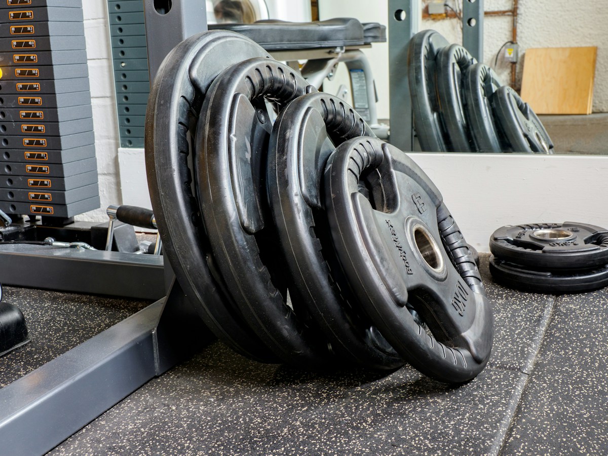 Disques de poids noirs empilés dans une salle de musculation
