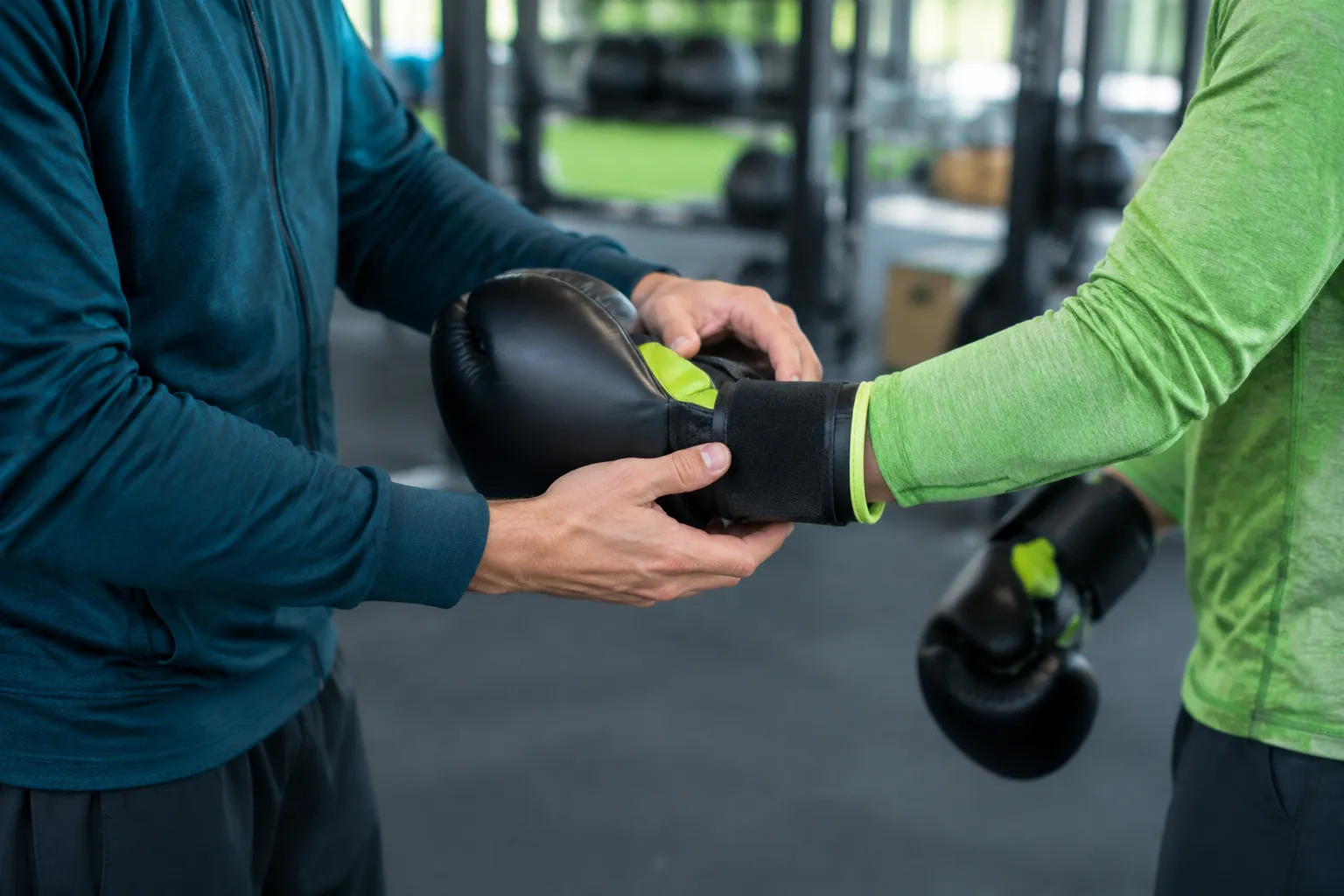 Entraîneur aidant à enfiler un gant de boxe noir